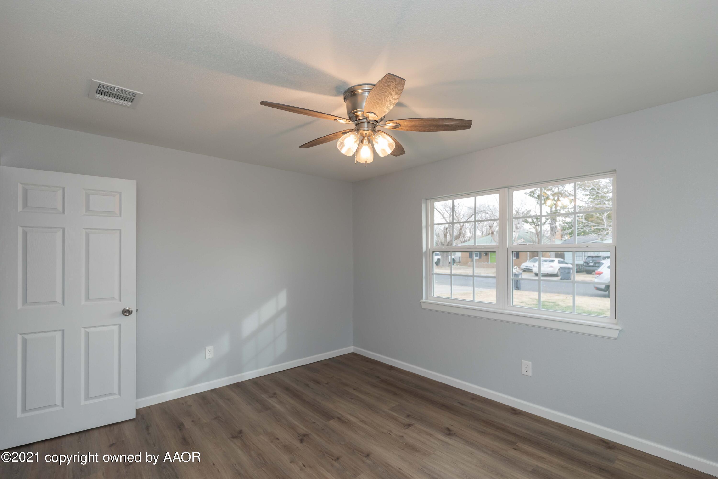 3808 Gables Street Amarillo, TX 79110 - Photo 14 of 23 a view of an empty room with a window and wooden floor