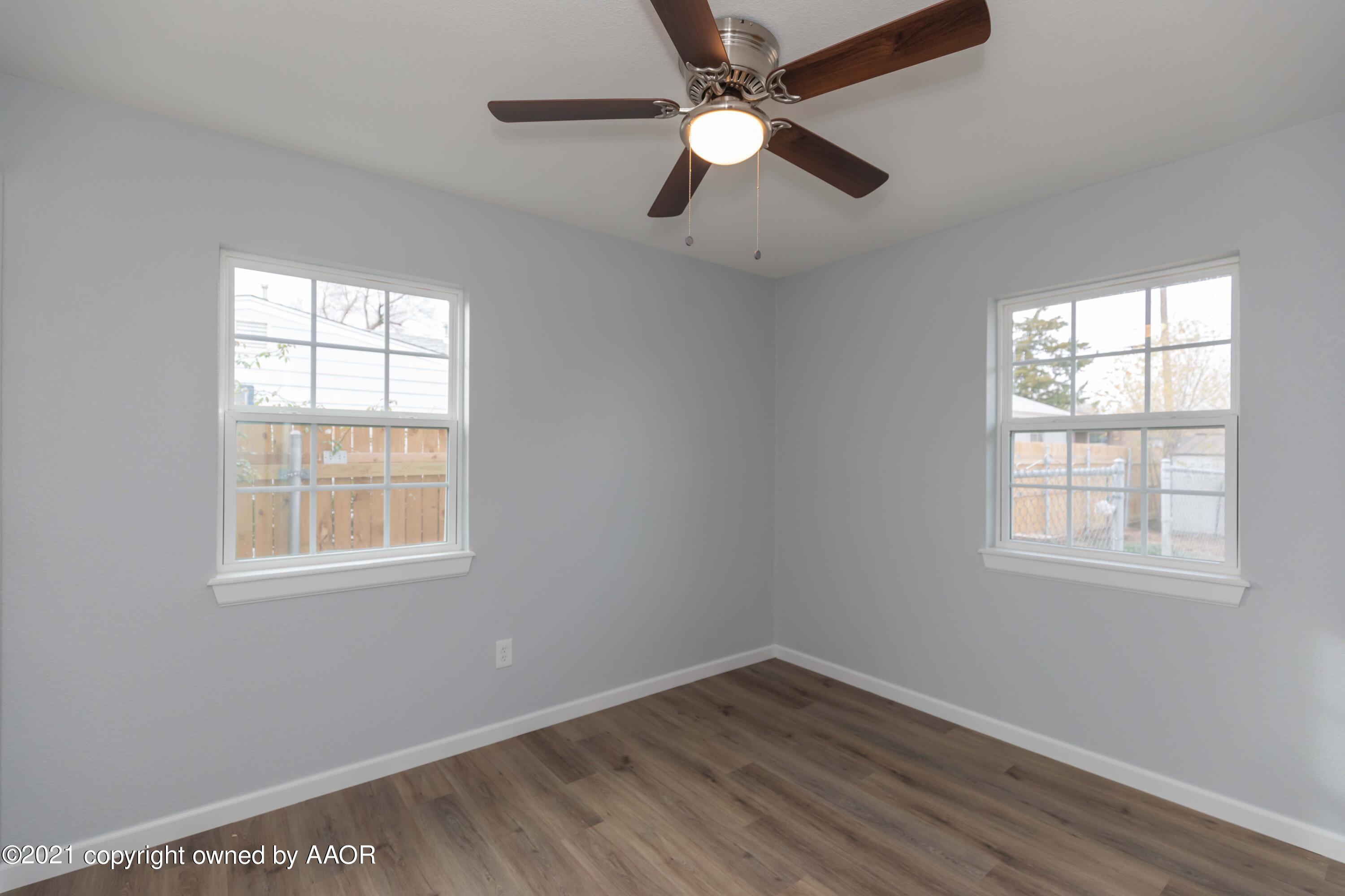3808 Gables Street Amarillo, TX 79110 - Photo 18 of 23 an empty room with wooden floor fan and windows