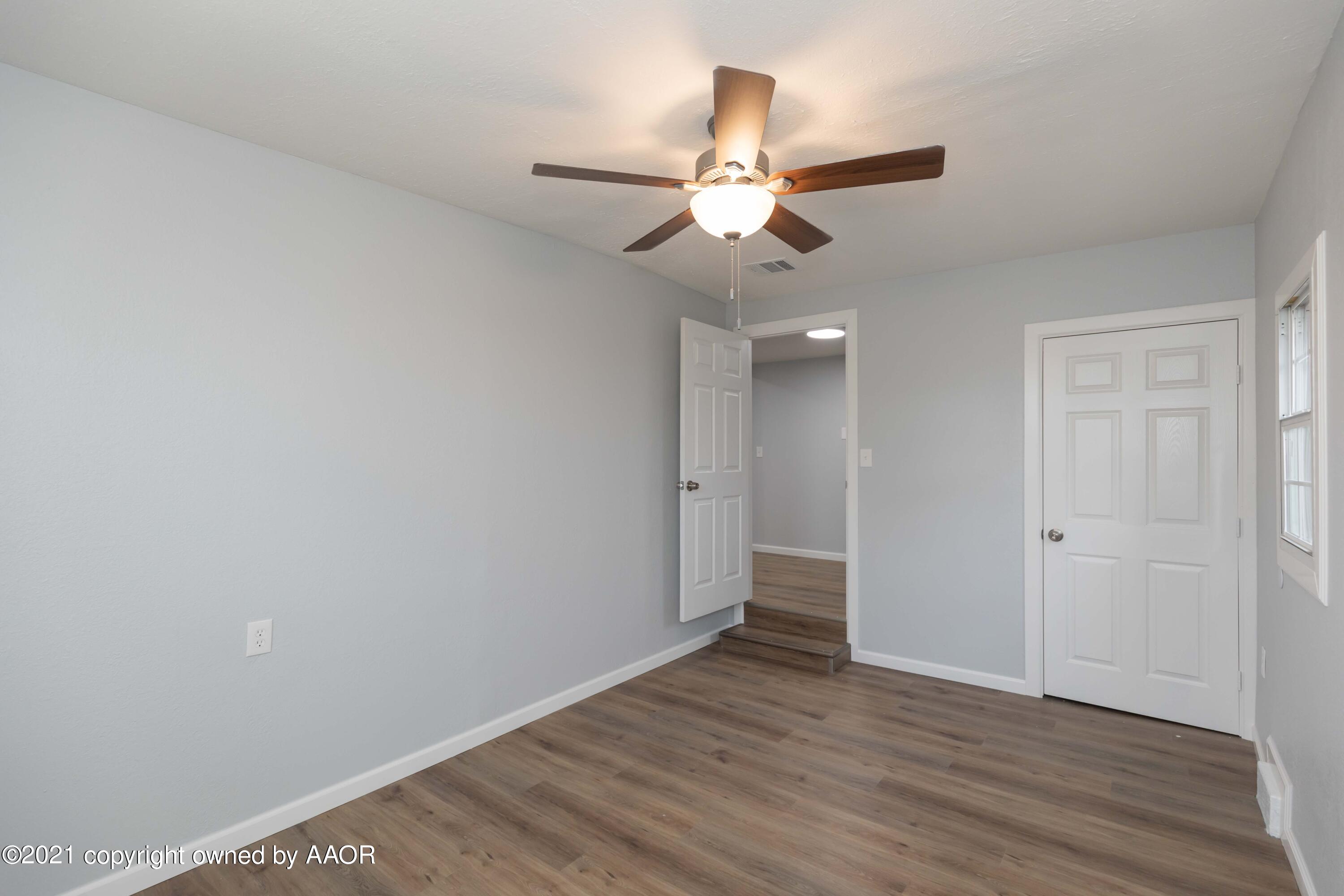 3808 Gables Street Amarillo, TX 79110 - Photo 19 of 23 an empty room with wooden floor fan and windows
