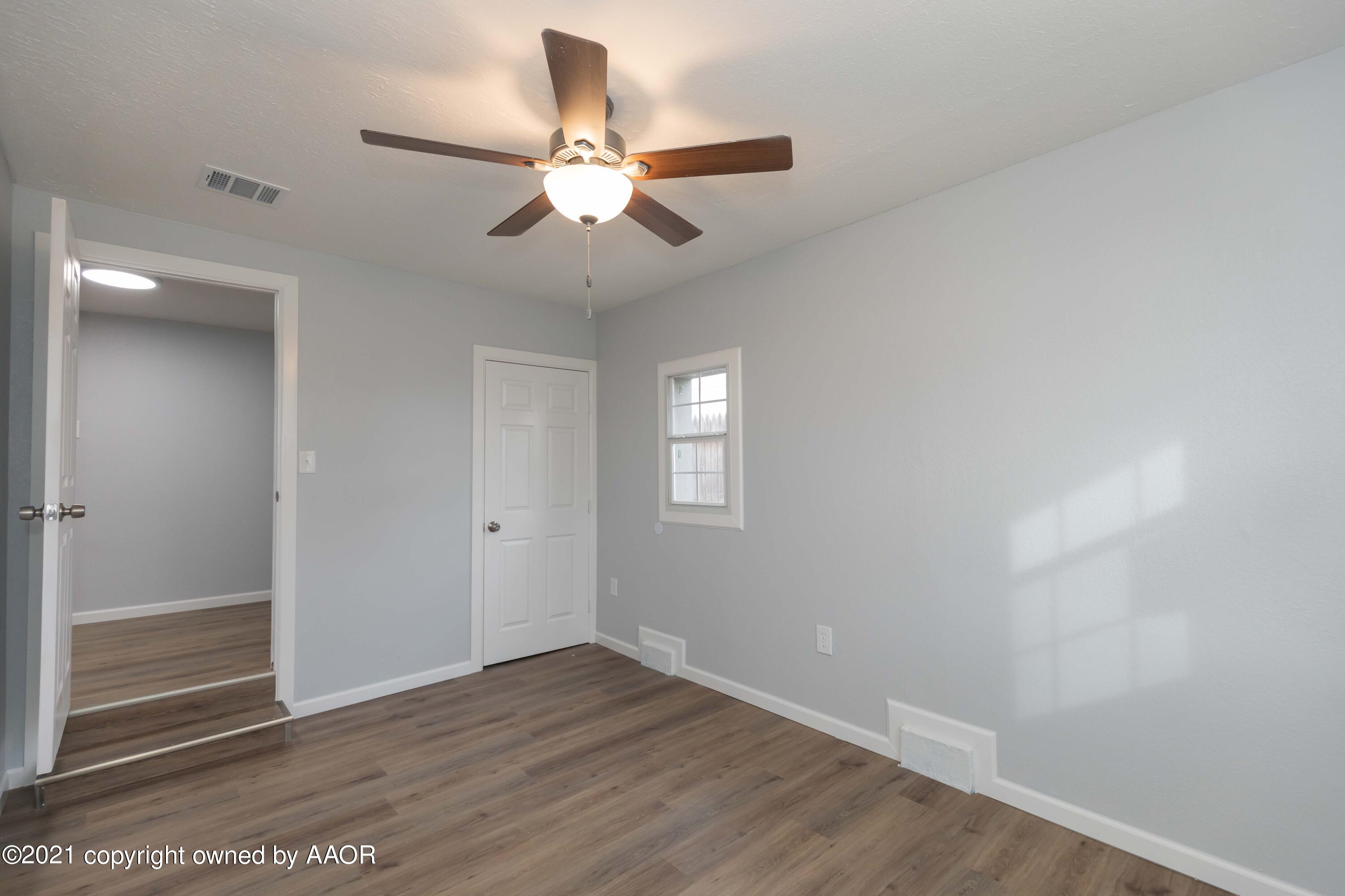 3808 Gables Street Amarillo, TX 79110 - Photo 20 of 23 an empty room with wooden floor fan and windows