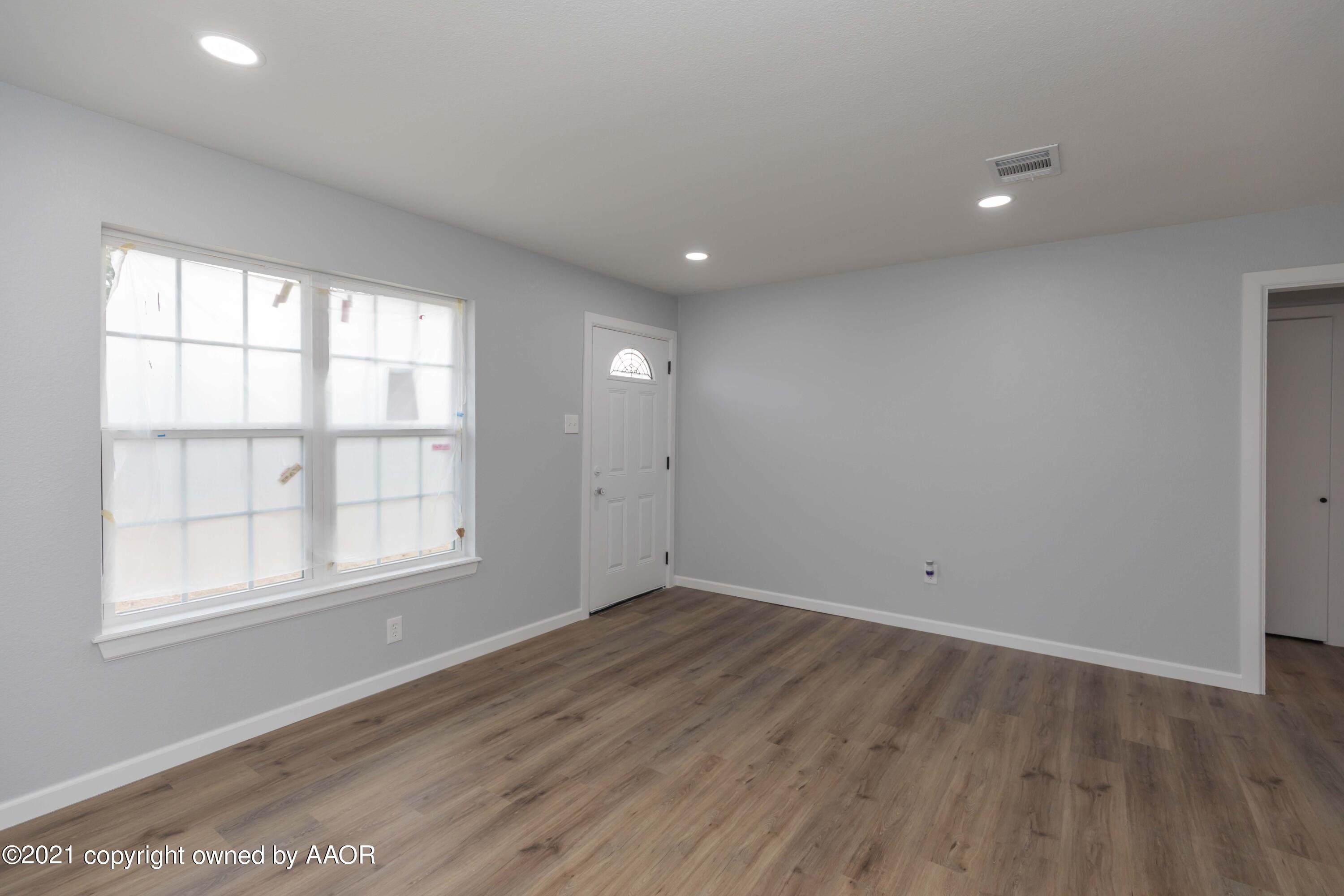 3808 Gables Street Amarillo, TX 79110 - Photo 4 of 23 an empty room with wooden floor and windows