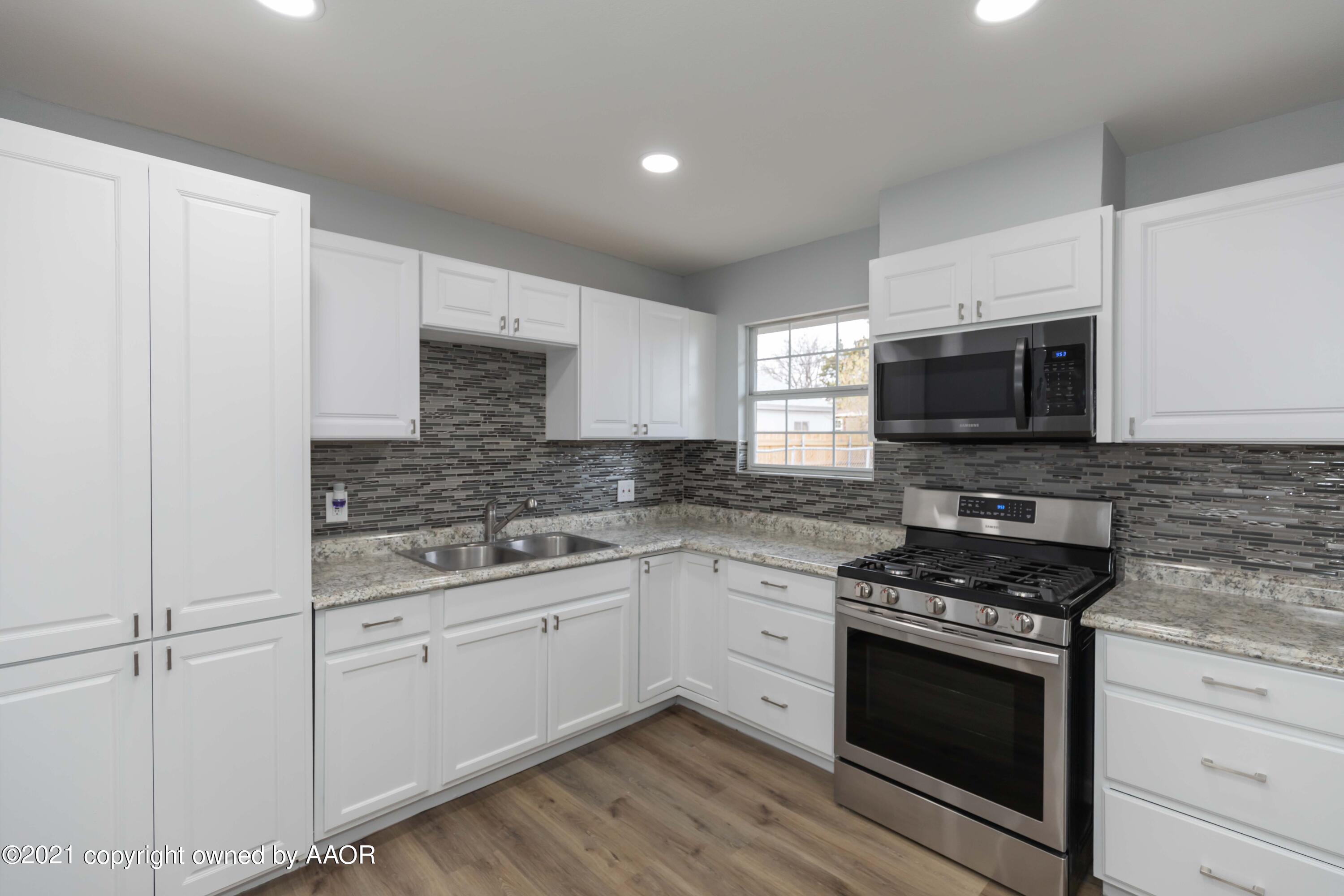 3808 Gables Street Amarillo, TX 79110 - Photo 5 of 23 a kitchen with granite countertop white cabinets stainless steel appliances and a sink