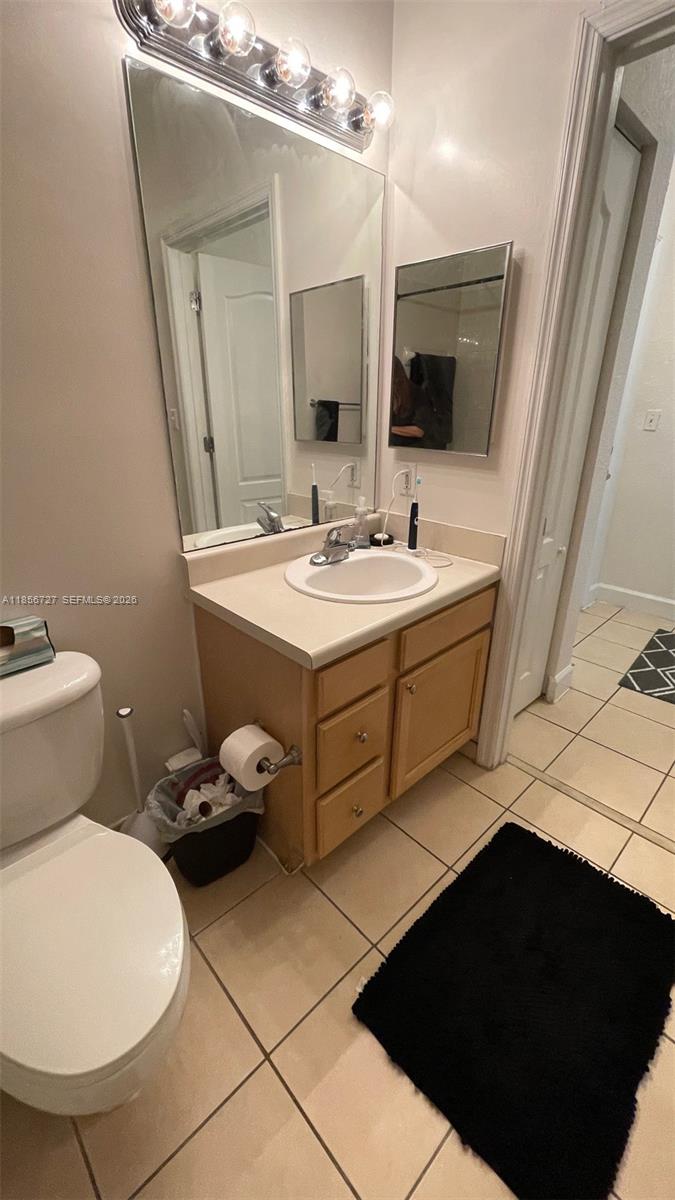 6001 Southwest 70th Street, Unit 127 South Miami, FL 33143 - Photo 11 of 13 a bathroom with a sink toilet and mirror