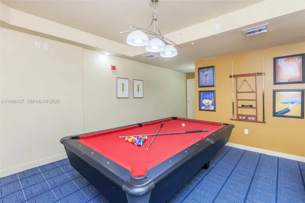 a room with pool table and windows