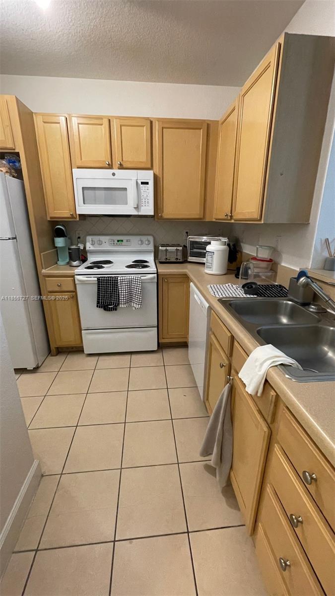 6001 Southwest 70th Street, Unit 127 South Miami, FL 33143 - Photo 9 of 13 a kitchen with a stove a sink and a microwave