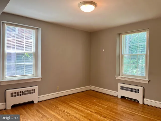 a view of a room with wooden floor and windows