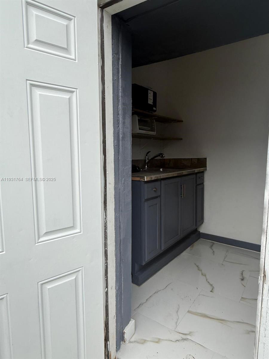 10357 Southwest 174th Terrace, Unit 1 Miami, FL 33157 - Photo 3 of 7 a kitchen with a refrigerator and cabinets