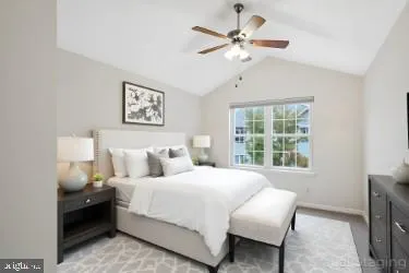 a bedroom with a bed painting on wall and a large window