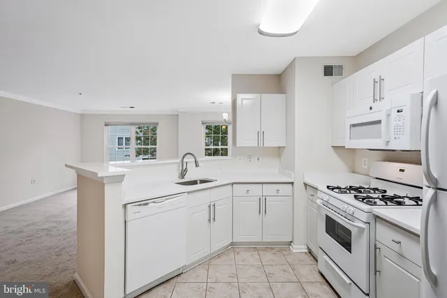 a kitchen with white cabinets and appliances