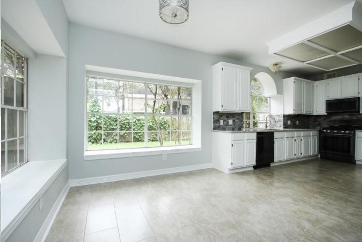 16222 Morningbrook Drive Spring, TX 77379 - Photo 15 of 44 a kitchen with stainless steel appliances kitchen island granite countertop a stove a sink and white cabinets