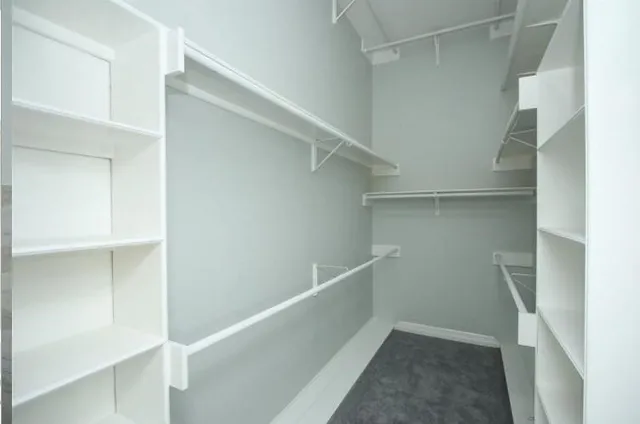 an empty room with a ceiling fan and a window