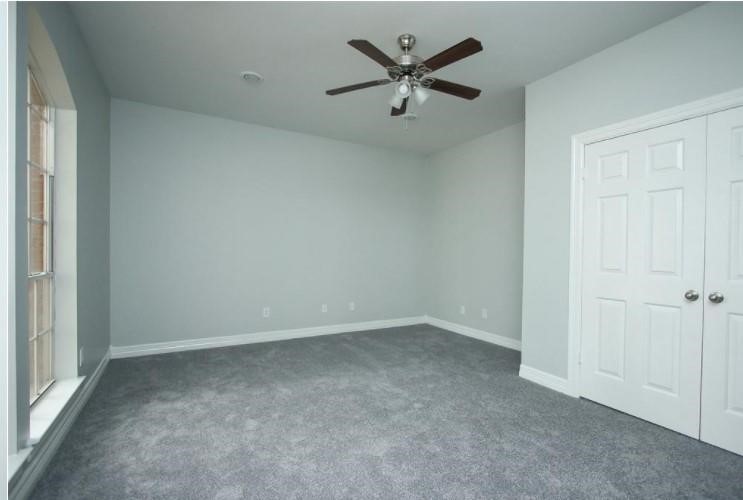 16222 Morningbrook Drive Spring, TX 77379 - Photo 25 of 44 an empty room with a ceiling fan and a window