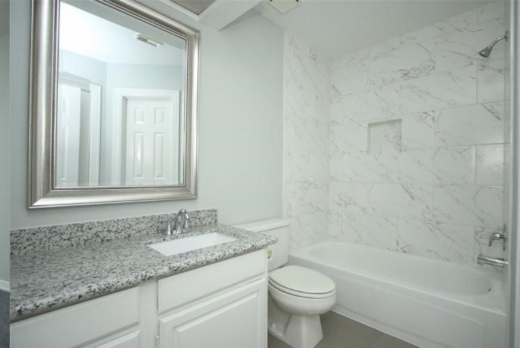 16222 Morningbrook Drive Spring, TX 77379 - Photo 30 of 44 a bathroom with a granite countertop sink a toilet and bathtub