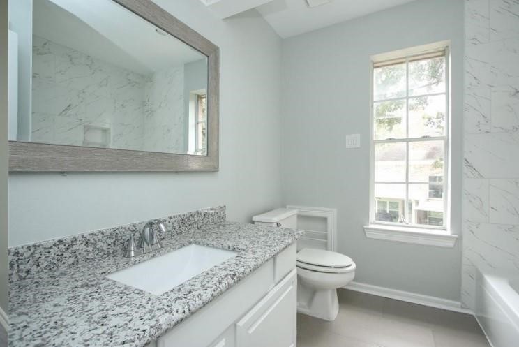 16222 Morningbrook Drive Spring, TX 77379 - Photo 32 of 44 a bathroom with a granite countertop toilet a sink and a mirror