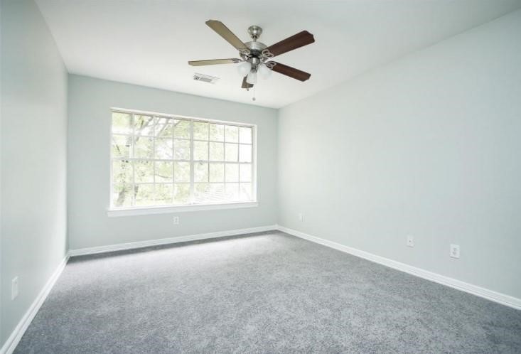 16222 Morningbrook Drive Spring, TX 77379 - Photo 33 of 44 an empty room with ceiling fan and windows