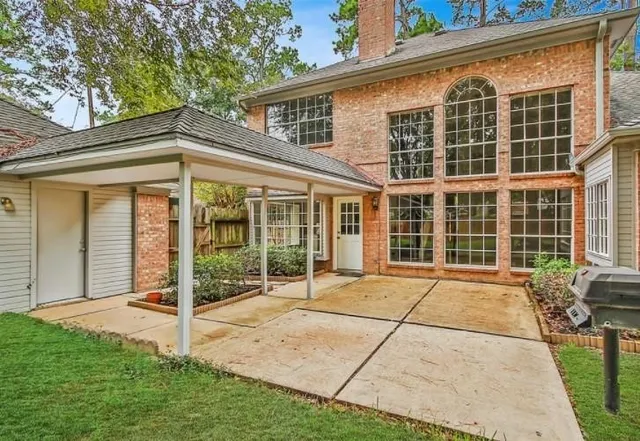 a view of a house with backyard and a tree