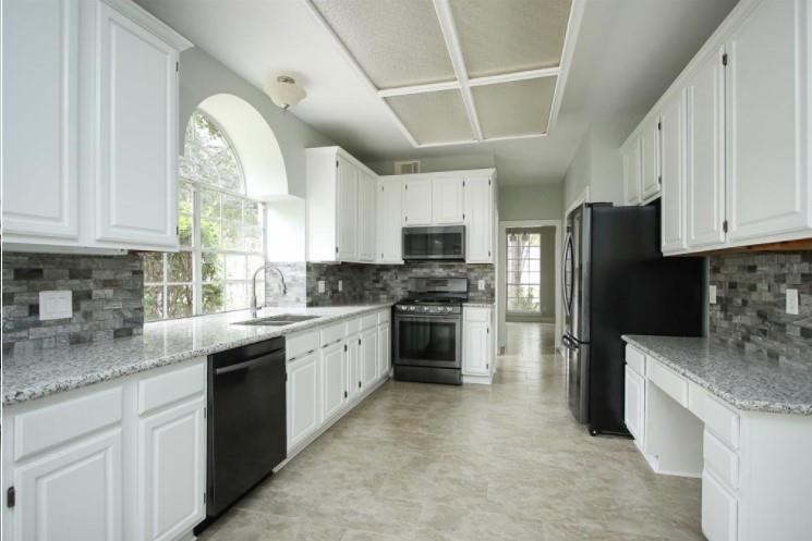 16222 Morningbrook Drive Spring, TX 77379 - Photo 7 of 44 a kitchen with granite countertop stainless steel appliances a refrigerator sink and microwave