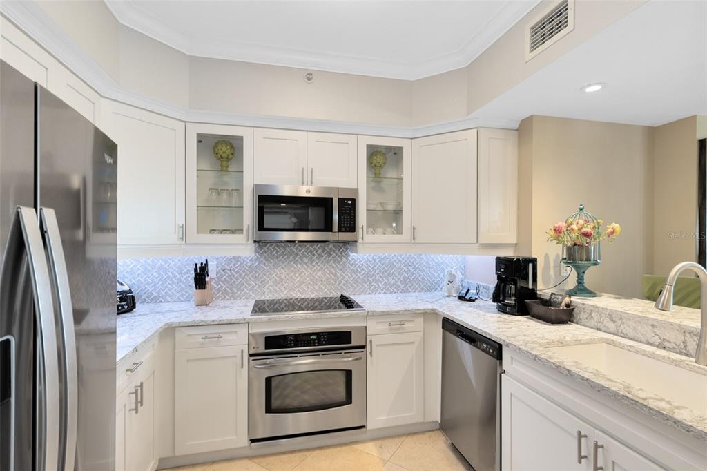 7593 Gathering Drive, Unit 501 Reunion, FL 34747 - Photo 4 of 38 a kitchen with stainless steel appliances granite countertop a sink stove and refrigerator