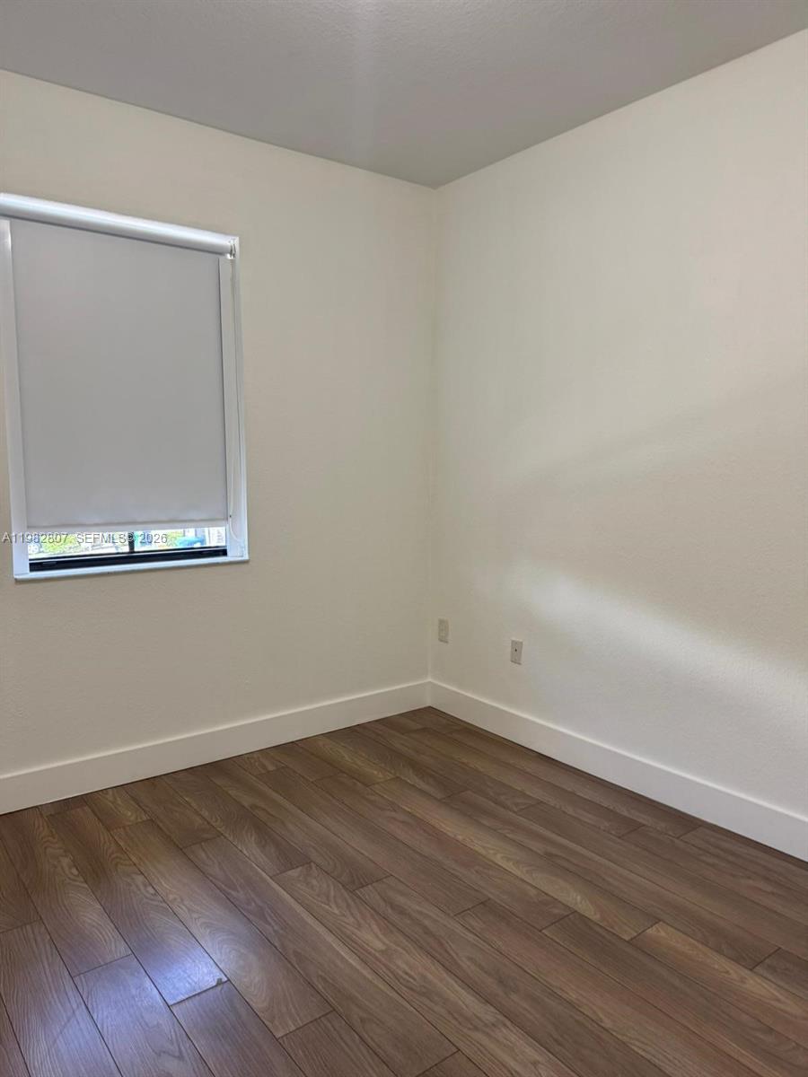 4217 Southwest 164th Court Miami, FL 33185 - Photo 13 of 15 a view of an empty room with wooden floor and a window