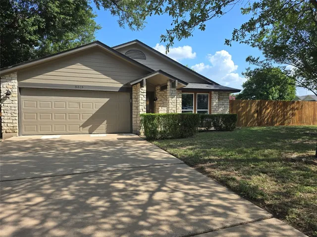 a front view of a house with a yard and trees