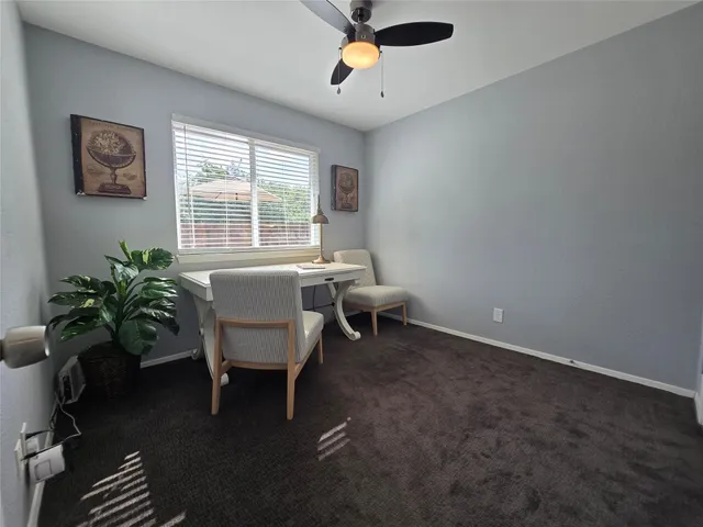 a view of patio with table and chairs under an umbrella with large trees