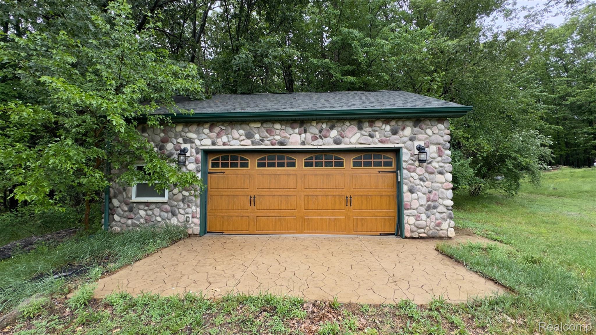 2608 East Sutton Road Metamora, MI 48455 - Photo 53 of 64 Stone veneer exterior garage featuring an arched panel garage door