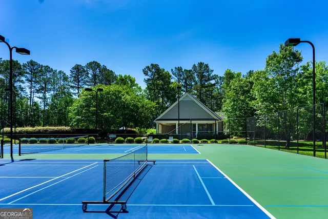a view of a tennis ground with large trees