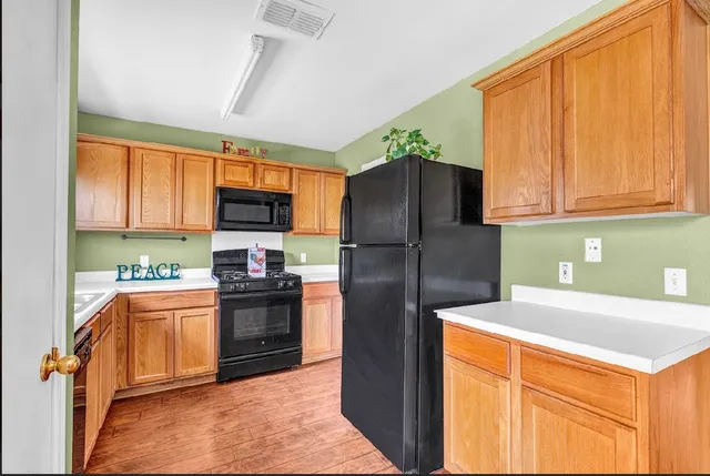 a kitchen with stainless steel appliances granite countertop a refrigerator stove top oven and sink