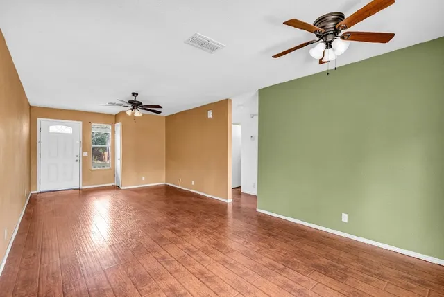 wooden floor in an empty room with a window