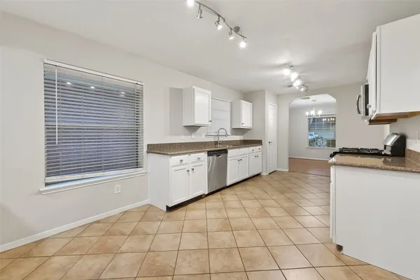 a large white kitchen with cabinets