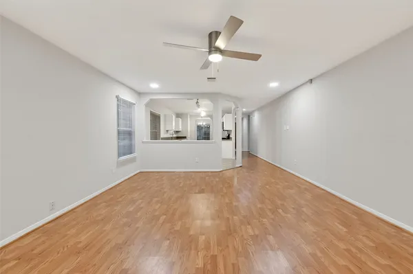 a view of a livingroom with a ceiling fan & hardwood floor