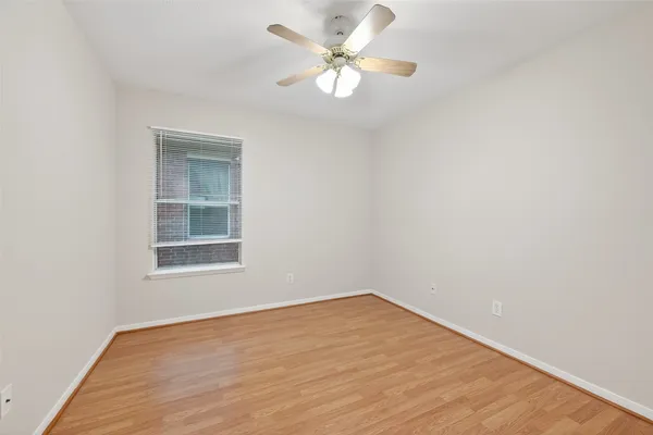 an empty room with a window and a fan