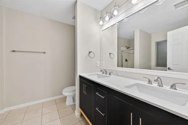 a bathroom with a double vanity sink toilet and a mirror