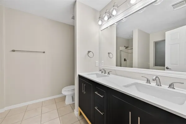 a bathroom with a double vanity sink toilet and a mirror