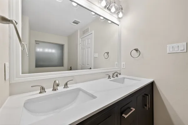 a bathroom with a sink double vanity and a mirror