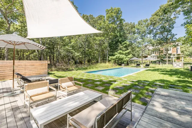 a view of a patio with table and chairs under an umbrella