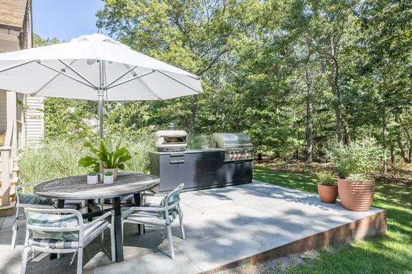 a patio with table and chairs under an umbrella