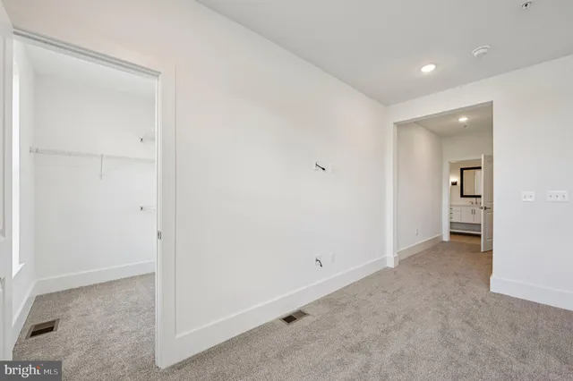 an empty room with closet and a bathroom