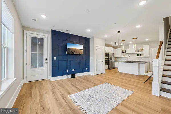 a large bedroom with a bed and a flat tv screen on dresser