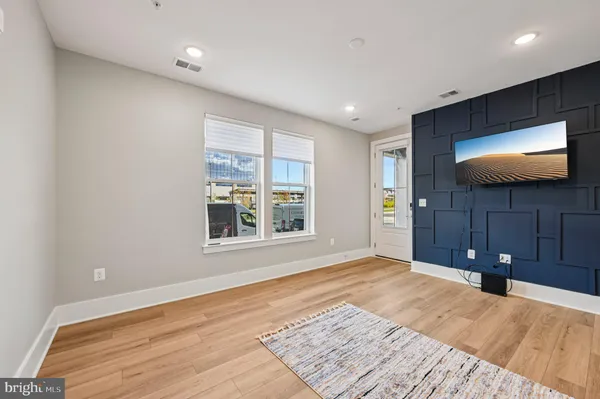 a view of a livingroom with wooden floor and a flat screen tv