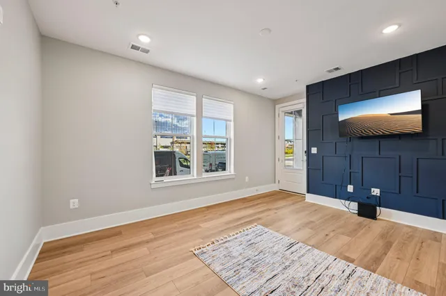 a view of a livingroom with wooden floor and a flat screen tv