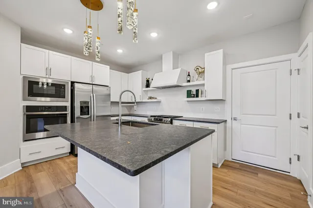 a kitchen with kitchen island a sink stainless steel appliances and a counter top space
