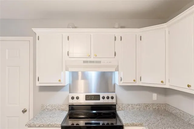 a kitchen with white cabinets and appliances