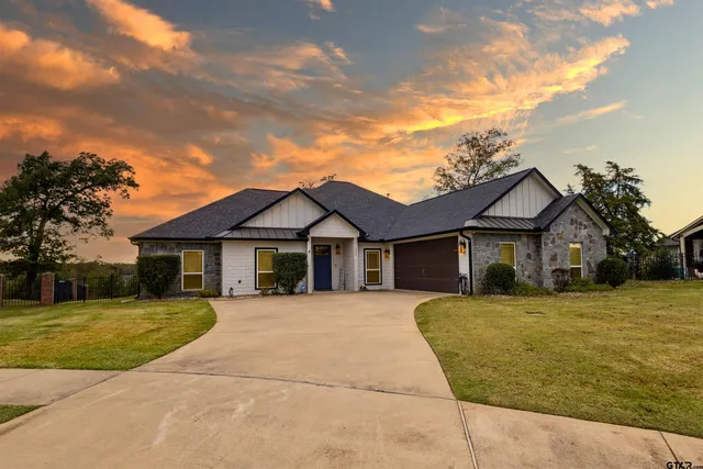 a view of a house with a big yard and large trees