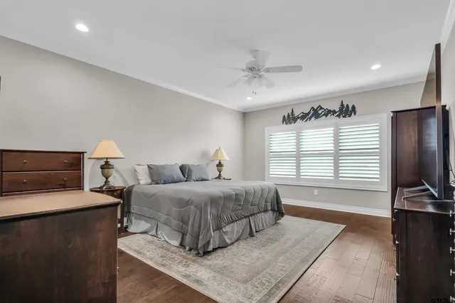 a spacious bedroom with a bed and a flat screen television