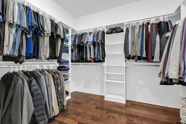 a view of walk in closet with clothes and shoes