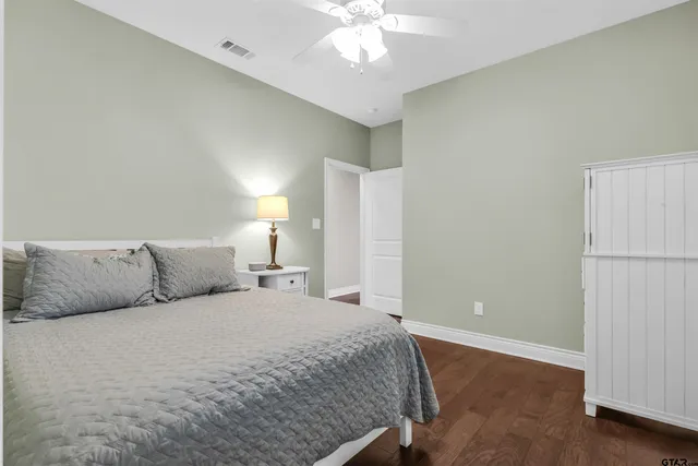 a bedroom with a large bed and a chandelier fan