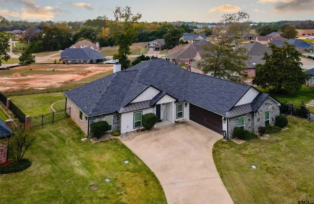 a aerial view of a house with a yard and mountain view in back
