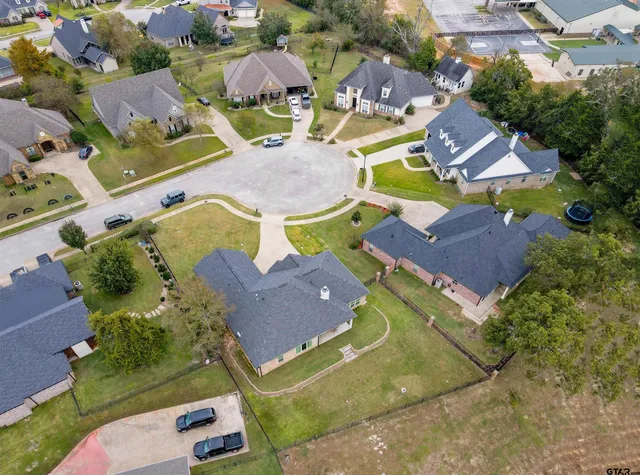 an aerial view of residential houses with outdoor space and parking