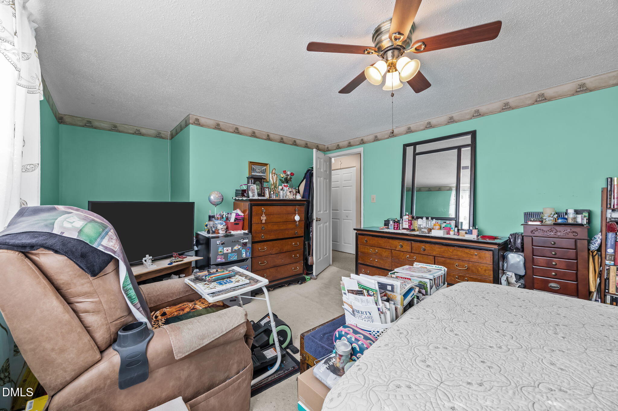 7740 Sandra Lane Raleigh, NC 27615 - Photo 15 of 36 a bedroom with a bed and a chandelier